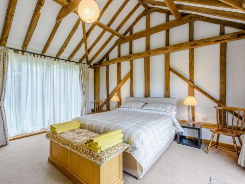 a bedroom with a bed in a room with wooden ceilings at Blackwell Barn in Raydon