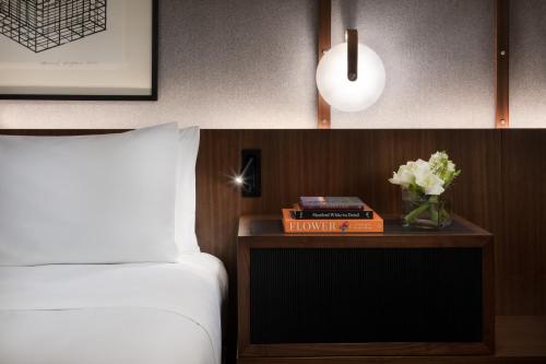 a bedroom with a bed and a table with a book and flowers at Hyatt Regency San Francisco Downtown SOMA in San Francisco