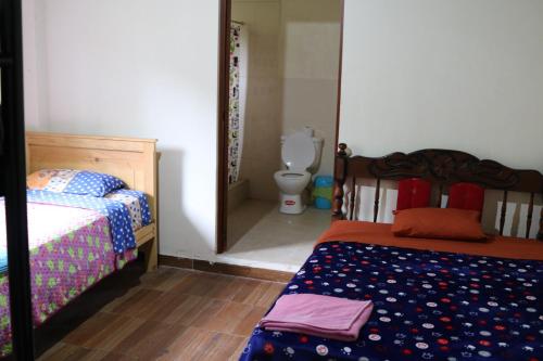 a bedroom with a bed and a toilet in a room at Candurumy Lodge in Tena