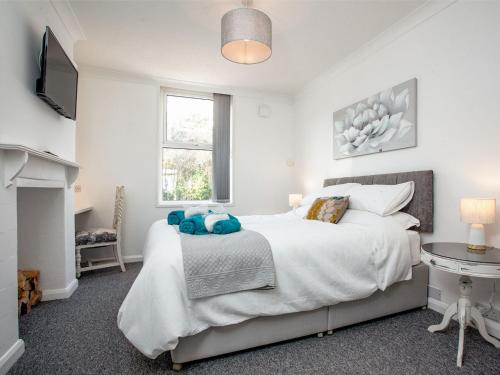 a white bedroom with a bed and a television at Herons Haven - Uk31452 in Paignton