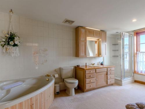 een badkamer met een bad, een toilet en een wastafel bij Psalter Farmhouse in Skendleby