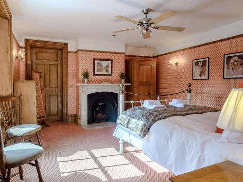 een slaapkamer met een bed en een open haard bij Psalter Farmhouse in Skendleby