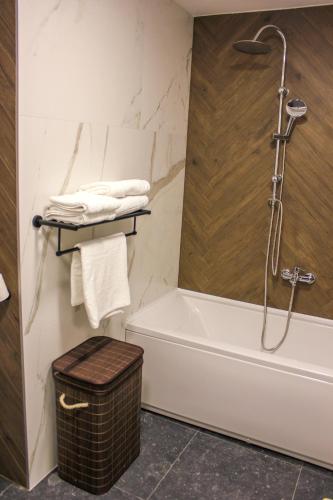 a bathroom with a tub and a shower with towels at Villa Wineyard - VinoGrad in Banja Luka