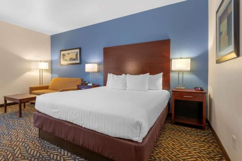 a hotel room with a large bed and a chair at Best Western Plus Covered Bridge Inn in Brazil