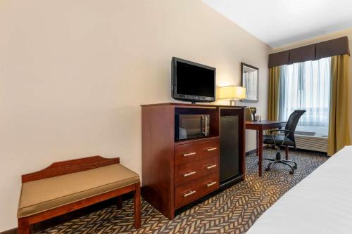 a hotel room with a bed and a desk and a television at Best Western Plus Covered Bridge Inn in Brazil