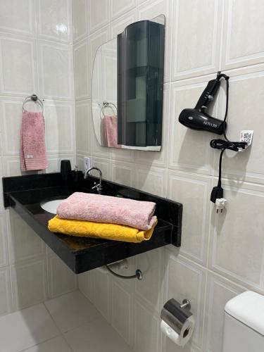 a bathroom with a sink and a mirror at Apartamento aconchegante com ar condicionado - Frade, Angra dos Reis in Angra dos Reis