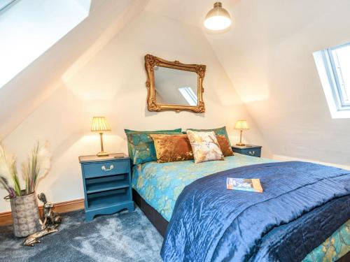 a bedroom with a blue bed and a mirror at Little Palm House in Reigate