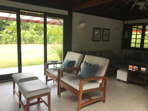 uma sala de estar com duas cadeiras e um sofá em Casa Thai na Praia do Forte