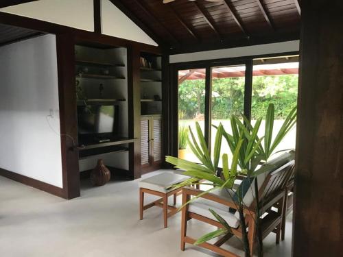 uma sala de estar com uma cadeira e uma planta em Casa Thai na Praia do Forte
