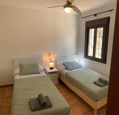 a bedroom with two beds and a window at Casa Rural Las Angosturas (Caminito del Rey) in El Chorro