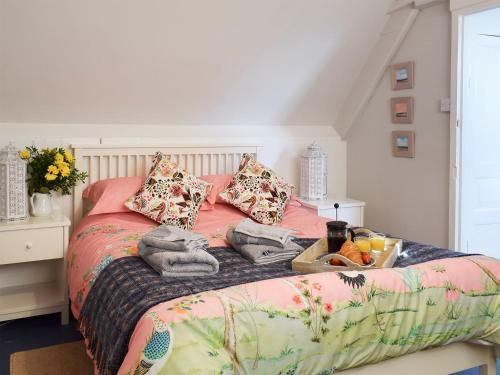 a bedroom with a bed with pink sheets and pillows at Rosslyn House in Robin Hood's Bay