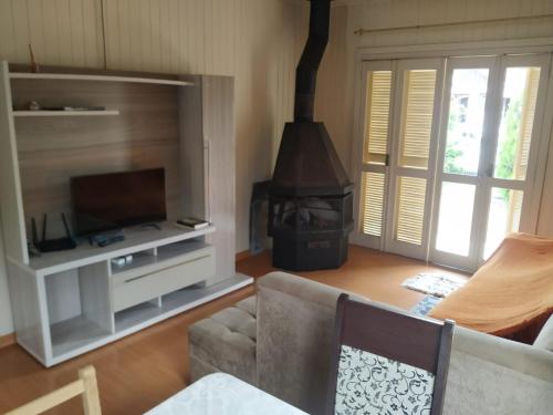 a living room with a couch and a fireplace at Cantinho da Tete in São Francisco de Paula