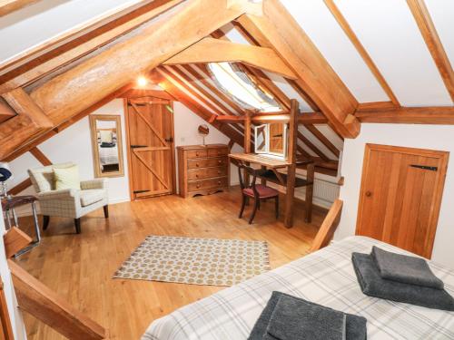 Schlafzimmer im Dachgeschoss mit einem Bett und einem Schreibtisch in der Unterkunft Cowslip Cottage in Haverfordwest
