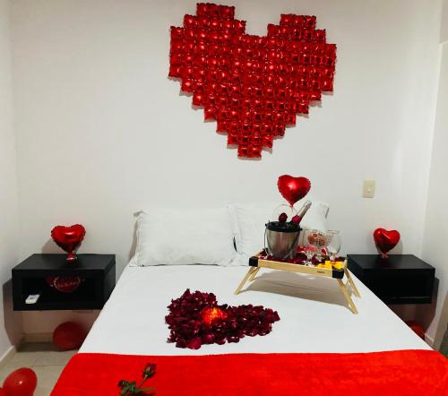 Una cama con un corazón hecho de corazones rojos en Apartamento JTR Maceió, en Maceió