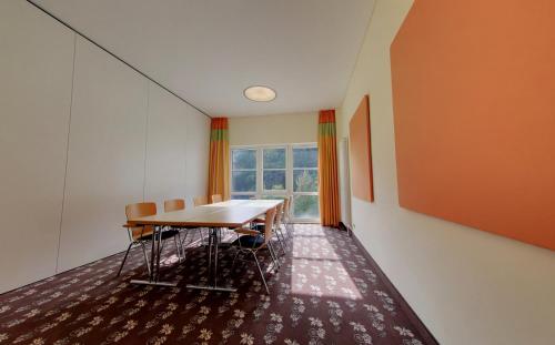 a dining room with a table and chairs and a window at Akzent Waldhotel Rheingau in Geisenheim