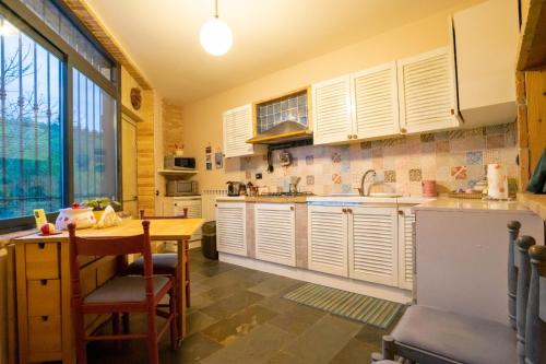 une cuisine avec des placards blancs et une table en bois dans l'établissement Casa Rosi - Loft tra i monti di Roccaraso, à Rionero Sannitico