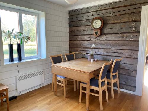 Villa Gasabäck في Söråker: غرفة طعام مع طاولة وساعة على الحائط