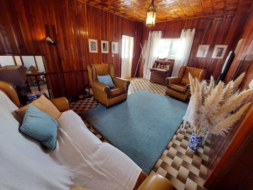 uma sala de estar com uma cama e duas cadeiras em Casa do Sobrado Arouca em Arouca