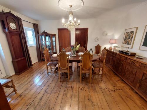 a dining room with a table and chairs and a chandelier at Casa do Sobrado Arouca in Arouca