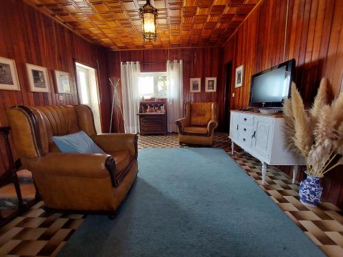 a living room with a couch and a television at Casa do Sobrado Arouca in Arouca