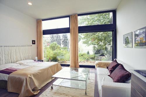 a bedroom with a bed and a couch and a large window at Apartment Breeze in Bratislava