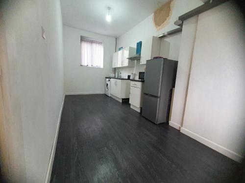 a kitchen with a refrigerator and white appliances in a room at Blackwood Residence in Accrington