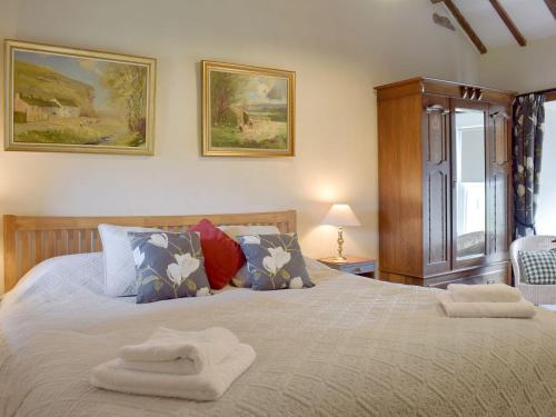 a bedroom with a bed with two towels on it at Cam Cottage in Kettlewell