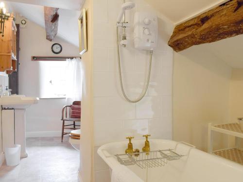 a bathroom with a bath tub and a sink at Cam Cottage in Kettlewell