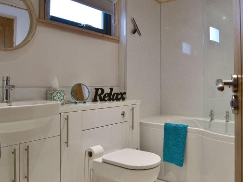 a white bathroom with a toilet and a sink at Cruachan in Etteridge