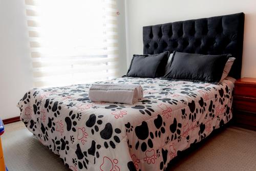 um quarto com uma cama com uma cabeceira preta em EXPECTACULAR APARTAMENTO OPORTUNOx em Bogotá