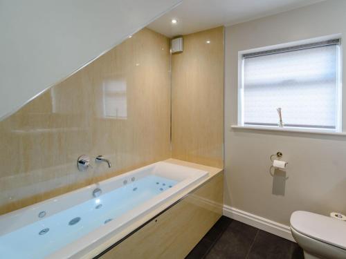 a bathroom with a tub and a window at Hunroe Brow in Reighton