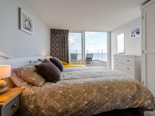 a bedroom with a bed with a view of the ocean at Hunroe Brow in Reighton