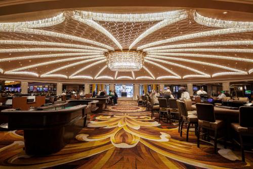 a casino with a large chandelier and tables and chairs at Caesars Palace Hotel & Casino in Las Vegas