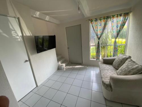 uma sala de estar com um sofá e uma grande janela em Punta del Sol Catarinas em Temixco