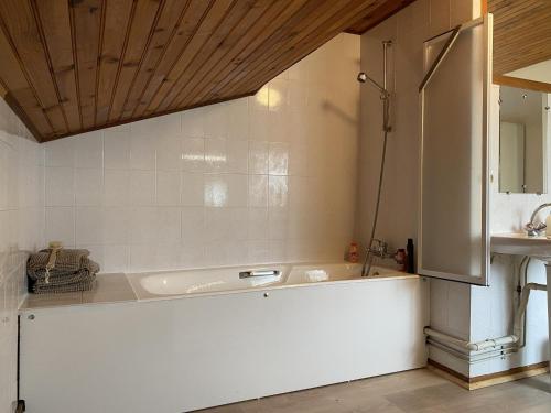 een badkamer met een wit bad en een wastafel bij Maison Bolbec 