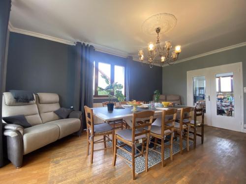 une salle à manger avec une table, des chaises et un canapé dans l'établissement Maison Bolbec, à Wadelincourt