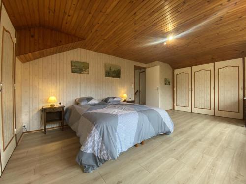 een slaapkamer met een bed en een houten plafond bij Maison Bolbec 