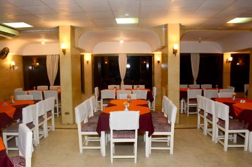 a restaurant with red and white tables and chairs at Shady Hotel Luxor in Luxor