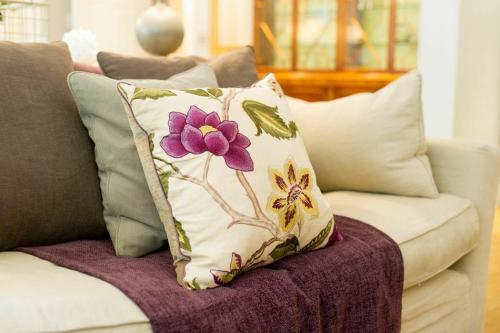 a pillow with a flower on a couch at 9 Hertford Street - 4 Stars VisitEngland in London