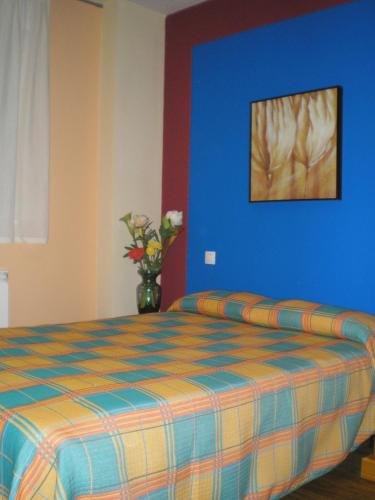 1 dormitorio con 1 cama con pared azul en Apartamentos Augusta Centro, en Zaragoza