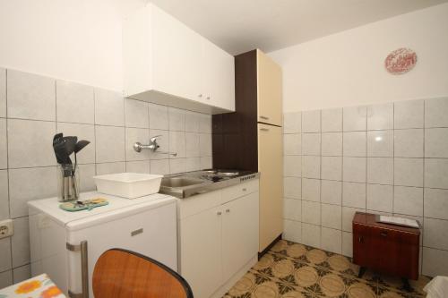 una pequeña cocina blanca con fregadero y encimera en Studio Brsec 2359a, en Brseč