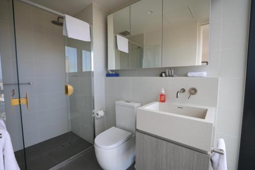 a bathroom with a toilet and a sink and a shower at Realm Apartments by CLLIX in Adelaide