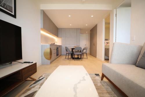 a living room with a couch and a table at Realm Apartments by CLLIX in Adelaide