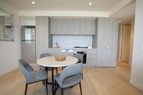 a kitchen and dining room with a table and chairs at Realm Apartments by CLLIX in Adelaide