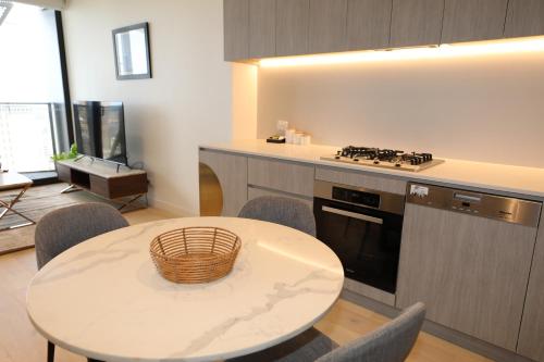 a kitchen with a table and a stove top oven at Realm Apartments by CLLIX in Adelaide