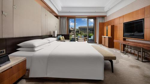 a bedroom with a large white bed and a television at InterContinental Kunming by IHG in Kunming