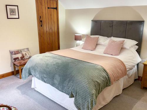 um quarto com uma cama grande e almofadas cor-de-rosa em Herrock View em Evenjobb