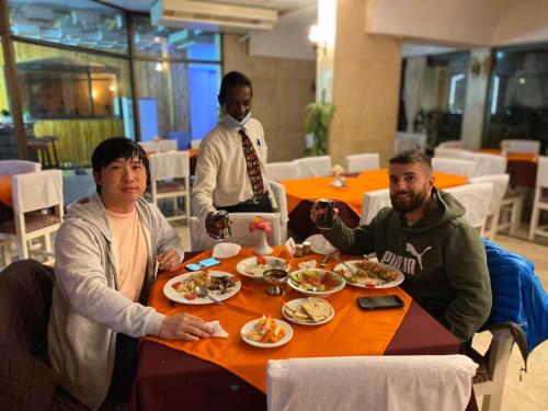 a group of people sitting at a table eating food at Shady Hotel Luxor in Luxor