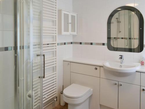 a white bathroom with a toilet and a sink at Reflections in Surfleet