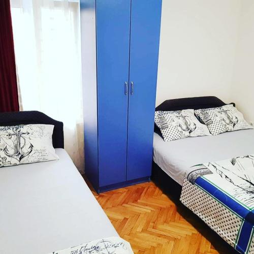 a bedroom with two beds and a blue cabinet at Montenegro Apartmant's in Kotor